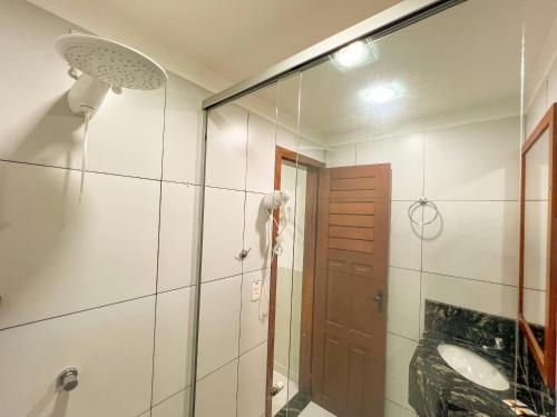 a bathroom with a shower and a glass door at Mini Hotel in Jericoacoara
