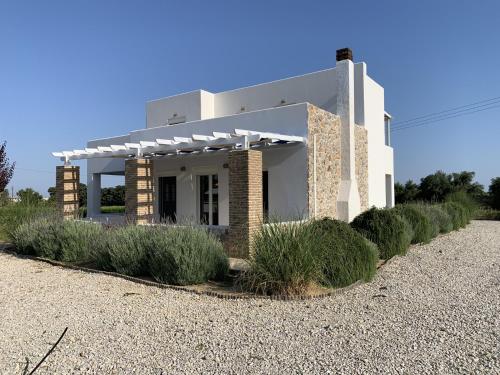 a white house with bushes in front of it at The Saint George in Mastichari