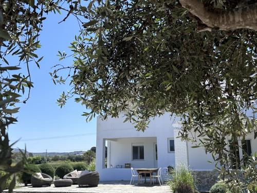 een wit huis met een tafel en wat bomen bij The Saint George in Mastichari