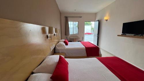 a hotel room with two beds and a flat screen tv at Nova Hotel in Cadereyta Jiménez