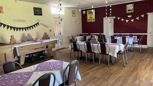 une salle à manger avec tables et chaises et nappes violettes dans l'établissement BJDS (dereham) ltd t/a kings head hotel, à East Dereham