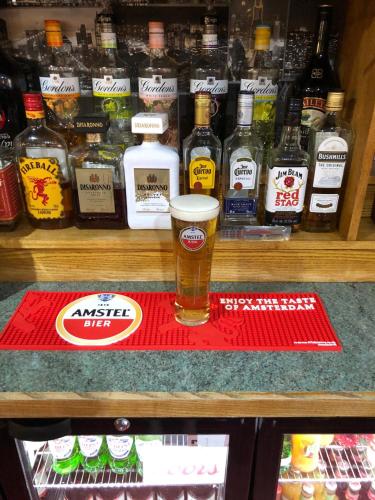 szklankę piwa siedzącą na czerwonej macie w lodówce w obiekcie BJDS (dereham) ltd t/a kings head hotel w mieście East Dereham