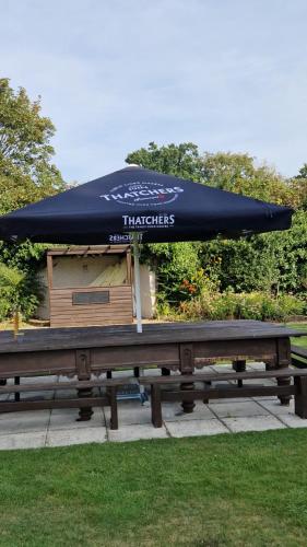 a picnic table with an umbrella on top of it at BJDS (dereham) ltd t/a kings head hotel in East Dereham