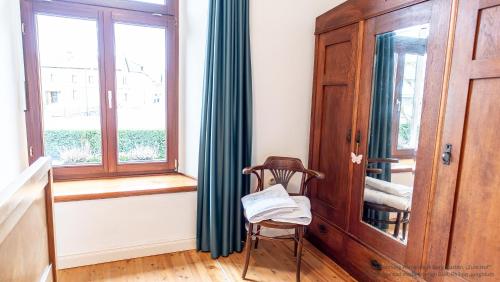 a chair sitting in a room with a window at Herrenhaus Burg Vlatten in Heimbach