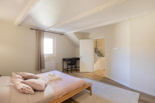 una camera da letto con un letto con cuscini sopra di L'antiquaire - 3 chambres - Hypercentre - Wifi a LʼIsle-sur-la-Sorgue
