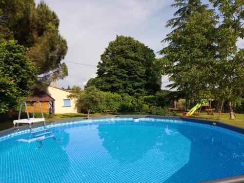 une grande piscine bleue avec toboggan dans l'établissement La Caillade, à Bayac