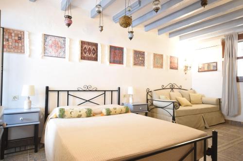 1 dormitorio con 2 camas y sofá en Masì House en Rodas