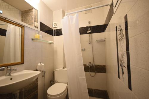 a bathroom with a toilet and a sink and a shower at Masì House in Rhodes Town