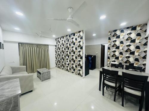 a living room with a couch and a table and chairs at Astha Powai Service Apartment in Mumbai