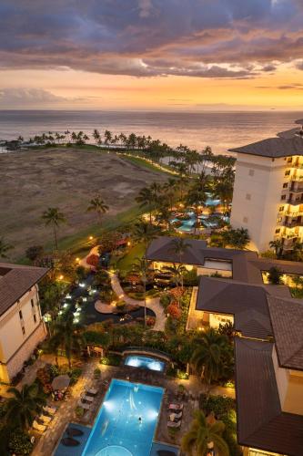 an aerial view of a resort with a pool and the ocean at Ko Olina Beach Villas O1402 in Kapolei