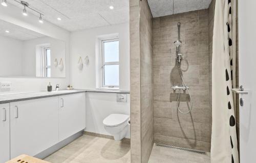 y baño blanco con aseo y ducha. en Gorgeous Home In Skagen With Wifi, en Skagen