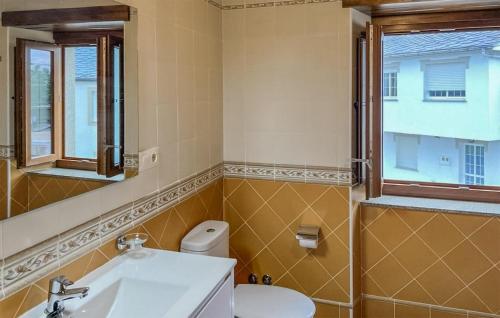 a bathroom with a toilet and a sink and a window at Stunning Apartment In O Porto De Espasante With Wifi in O Porto de Espasante
