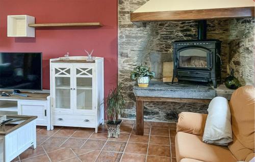 a living room with a fireplace and a stove at Cozy Apartment In O Porto De Espasante in Porto de Espasante