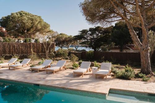 a group of lounge chairs next to a swimming pool at Boutique Hotel Villa Salvador - Adults Only by Fimedhotels in Cadaqués
