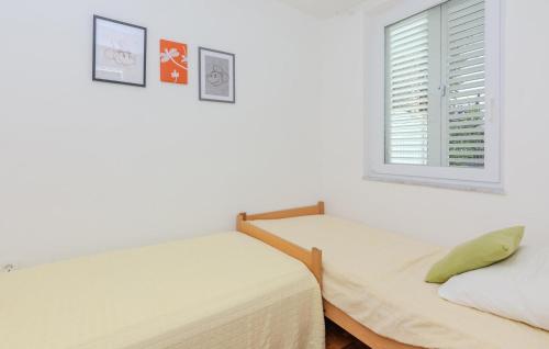 Duas camas num quarto branco com uma janela em 1 Bedroom Cozy Apartment In Nin em Nin