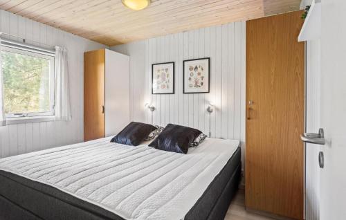 um quarto com uma cama grande e uma janela em Awesome Home In Vggerlse With Kitchen em Bøtø By