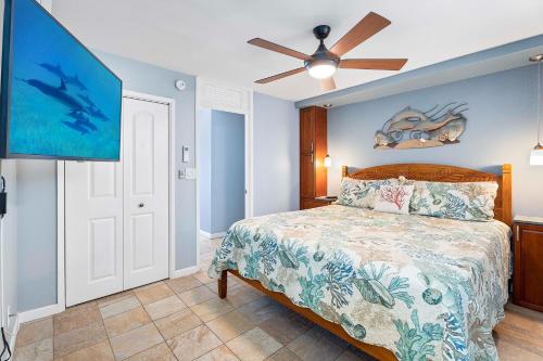 a bedroom with a bed and a flat screen tv at Kona Alii 403 in Kailua-Kona