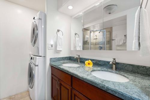 a bathroom with two sinks and a refrigerator at Kona Alii 403 in Kailua-Kona
