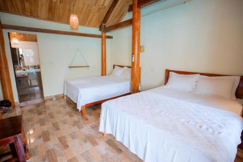 a bedroom with two beds in a room at Phong Nha Ecolodge Homestay By HOFs in Phong Nha