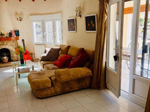 sala de estar con sofá y chimenea en Belvilla by OYO Casa Alegria, en Cumbre del Sol