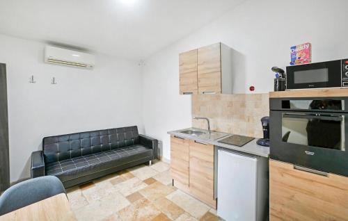 d'une cuisine avec un canapé dans le coin d'une pièce. dans l'établissement Nice Apartment In Jonquières-Saint-Vince, à Jonquières-et-Saint-Vincent