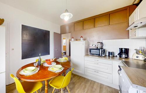 une cuisine avec une table en bois et des chaises jaunes dans l'établissement Gorgeous Apartment In Locmariaquer, à Locmariaquer