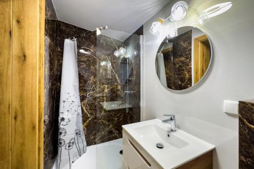 uma casa de banho com um lavatório e um espelho em NORDHOUSE II em Jastrzebia Gora