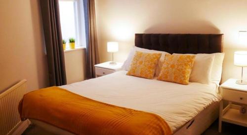 a bed with orange and white pillows in a room at Eurostar Budget Rooms - Next to Kings Cross & Eurostar Train Station in London