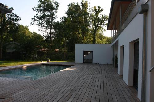 un patio trasero con piscina y una casa en Lazuli Lodge, en Azur