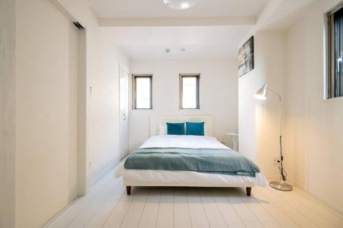 東京的住宿－オーシャンズスイート 東京ディズニーリゾートマリンバルコニー303室，白色卧室配有蓝色枕头的床