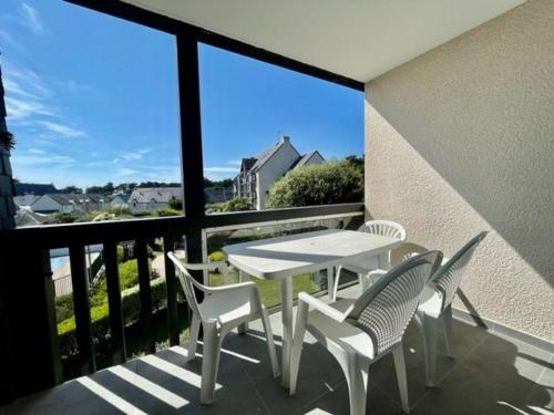 une table blanche et des chaises sur un balcon avec vue dans l'établissement Appartement 2 pièces avec balcon, piscine et parking, à 1km de la plage - Animaux acceptés - FR-1-478-27, à Quiberon