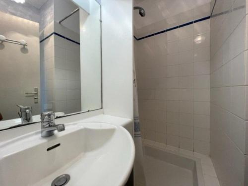 une salle de bain blanche avec un lavabo et un miroir dans l'établissement Appartement 2 pièces avec balcon, piscine et parking, à 1km de la plage - Animaux acceptés - FR-1-478-27, à Quiberon
