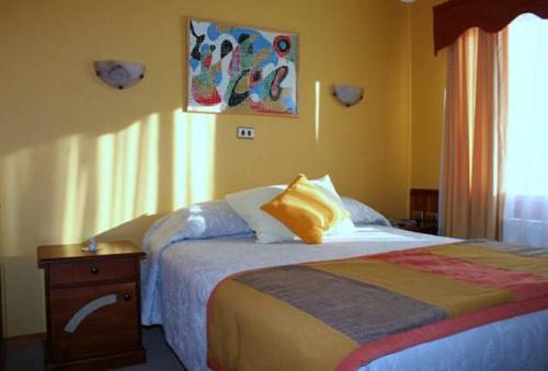 a bedroom with a bed with a wooden nightstand and a bed sidx sidx sidx at Hotel Caleta in San Miguel