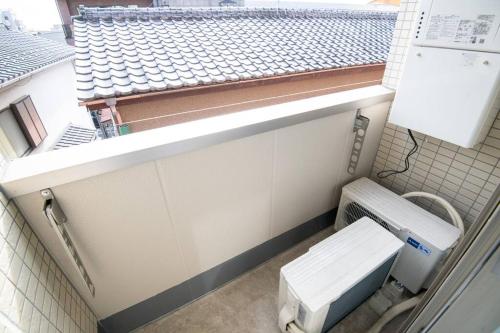 東京的住宿－オーシャンズスイート 東京ディズニーリゾートマリンバルコニー303室，一间带卫生间和窗户的小浴室