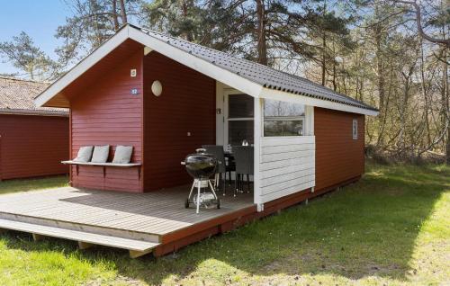 a red and white shed with a grill on a deck at Lovely Home In Nexø With Wifi in Neksø