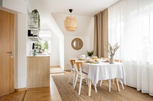 a dining room with a white table and chairs at Giewont Mountain View Apartment in Zakopane