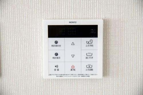 a white remote control on a wall with symbols on it at オーシャンズスイート 東京ディズニーリゾートマリンバルコニー303室 in Tokyo