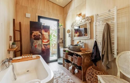 uma casa de banho com banheira e um cartaz de cão na parede em Nice Home In Robion With House A Panoramic View em Robion en Luberon