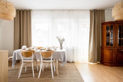 a dining room with a table and chairs and a window at Giewont Mountain View Apartment in Zakopane