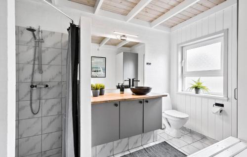 y baño blanco con ducha y aseo. en Amazing Home In Lkken With Sauna, en Løkken