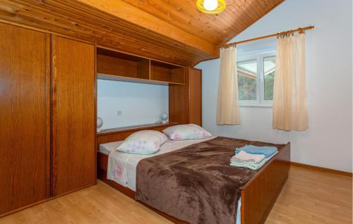a small bedroom with a bed with a window at Stunning Apartment In Banjol With Wifi in Banjol