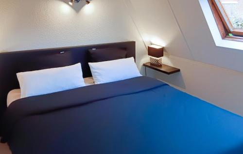 ミッデルケルケにあるGolf 3のベッドルーム1室(青い毛布、窓付)
