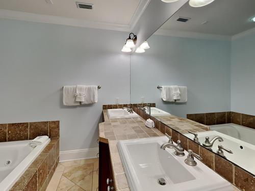 a bathroom with two sinks and a bathtub and a tub and a tubermott at Adagio 101f in Santa Rosa Beach