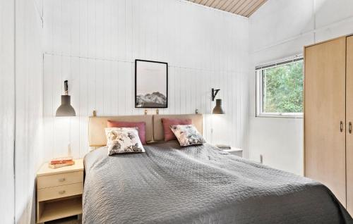 a bedroom with a large bed with two pillows at 4 Bedroom Pet Friendly Home In Vggerlse in Bøtø By