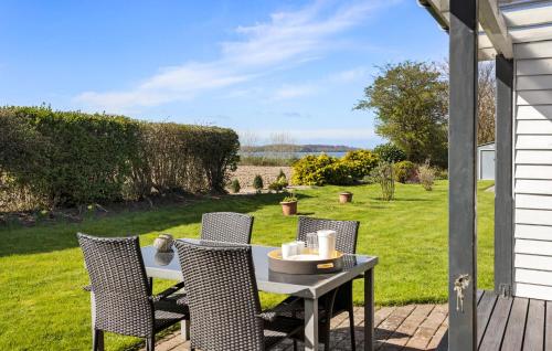 Una mesa y sillas en un patio con vista a un jardín. en Gorgeous Home In Svendborg With Wifi, en Svendborg
