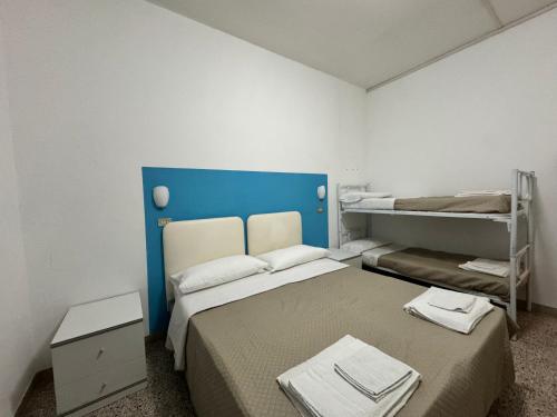 una camera con 2 letti a castello e una testiera blu di Hotel Serafini a Rimini