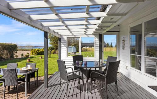 a pergola on a deck with a table and chairs at Gorgeous Home In Svendborg With Wifi in Svendborg