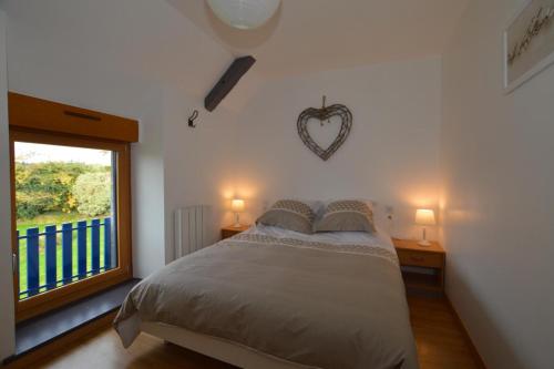 a bedroom with a bed with a heart on the wall at De dartagnan in La Fontenelle