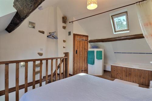 a bedroom with a bed and a tub in a room at La petite maison bleue in Les Portes du Coglais