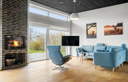 a living room with blue chairs and a fireplace at Awesome Home In Thyholm With Wifi in Thyholm